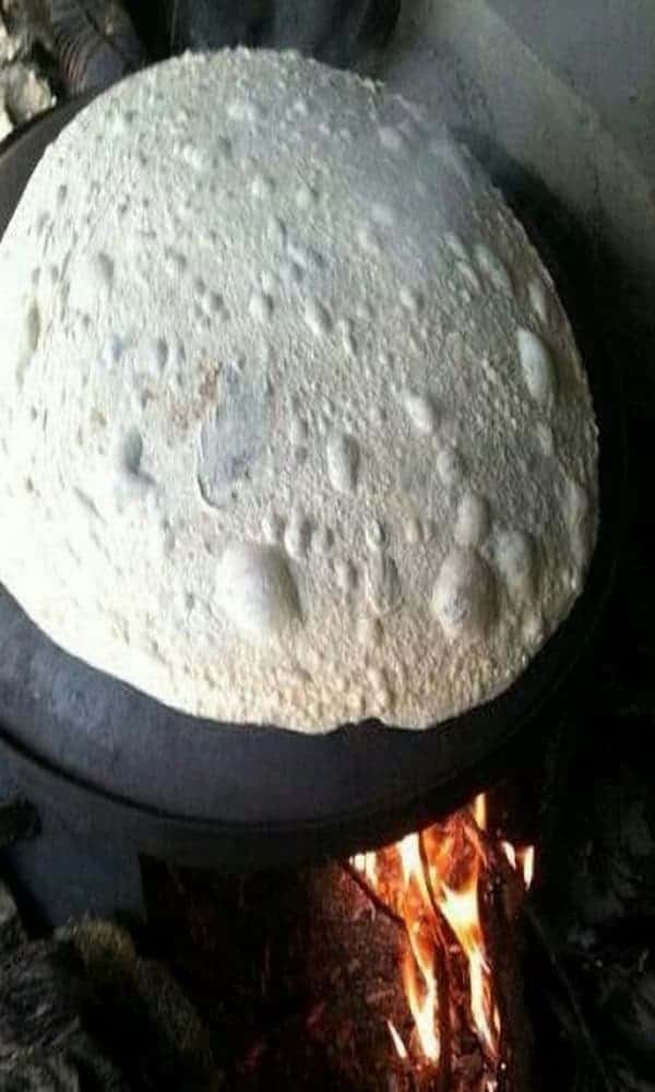 Preparazione manuale del pane taboon durante un’esperienza locale a Petra